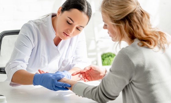 Doctor looking at patients arm.