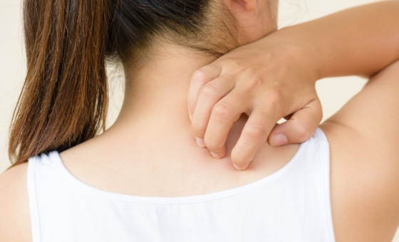 Girl scratching the back of her neck.